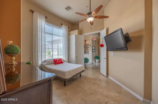 a room with chandelier fan and windows