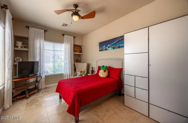 a bedroom with a bed and a flat tv screen on the dresser