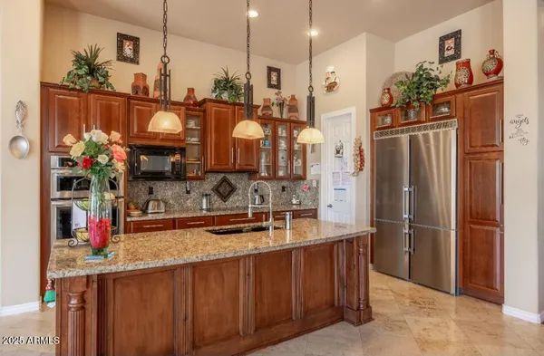 a kitchen with stainless steel appliances granite countertop a refrigerator and a sink