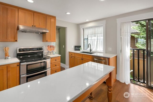 a kitchen with stainless steel appliances a stove sink and cabinets