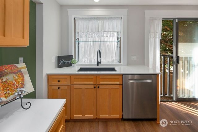 a kitchen with stainless steel appliances granite countertop a sink and a wooden cabinets