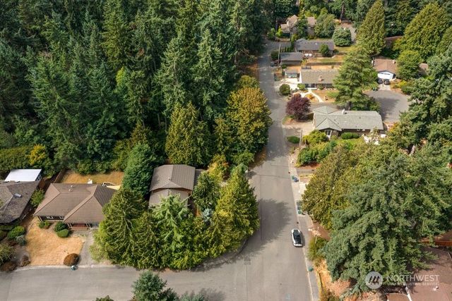 an aerial view of residential house with outdoor space and trees all around