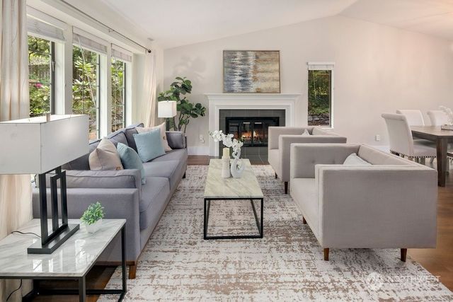 a living room with furniture a large window and a fireplace