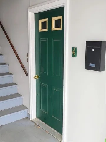 a view of a hallway with entryway and stairs