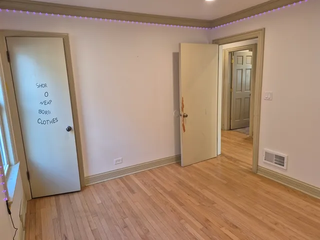 an empty room with wooden floor and a mirror