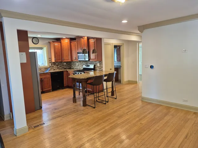 a view of a a dining room with furniture window and wooden floor