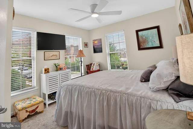 a bedroom with a bed a window and a flat screen tv