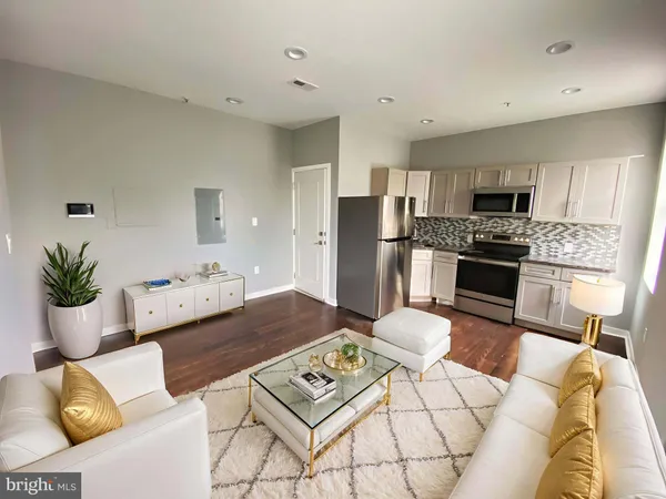 a living room with furniture and kitchen view