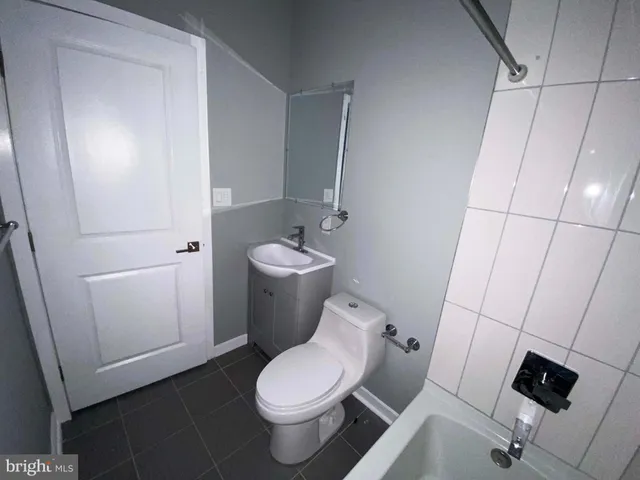 a white toilet sitting next to a bathroom sink and vanity