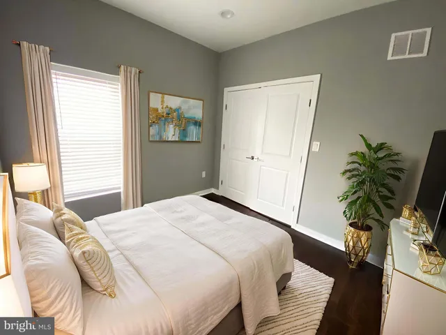 a bedroom with a bed and a potted plant