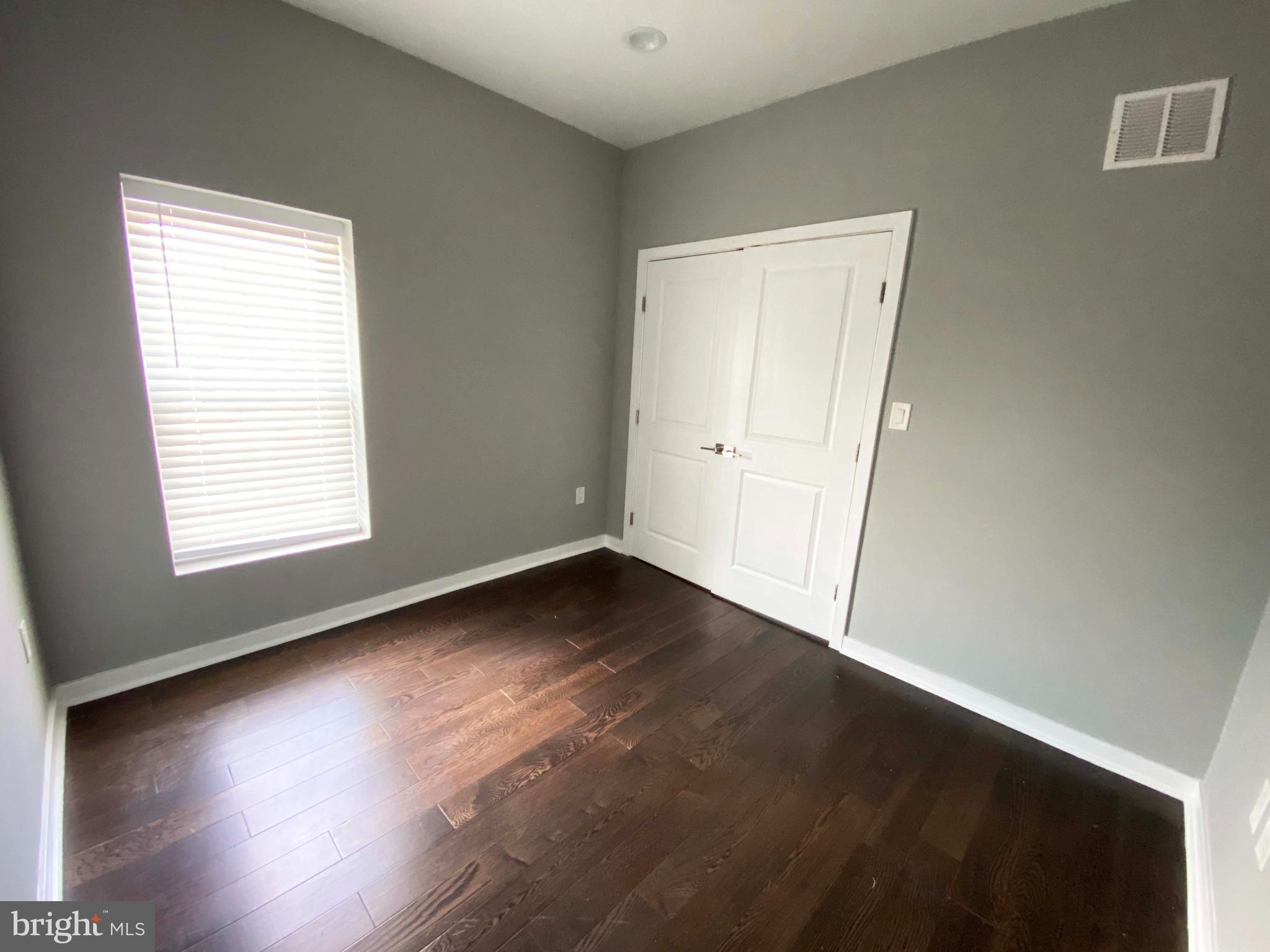 1801 West Venango Street, Unit 4 Philadelphia, PA 19140 - Photo 16 of 21 an empty room with wooden floor and windows
