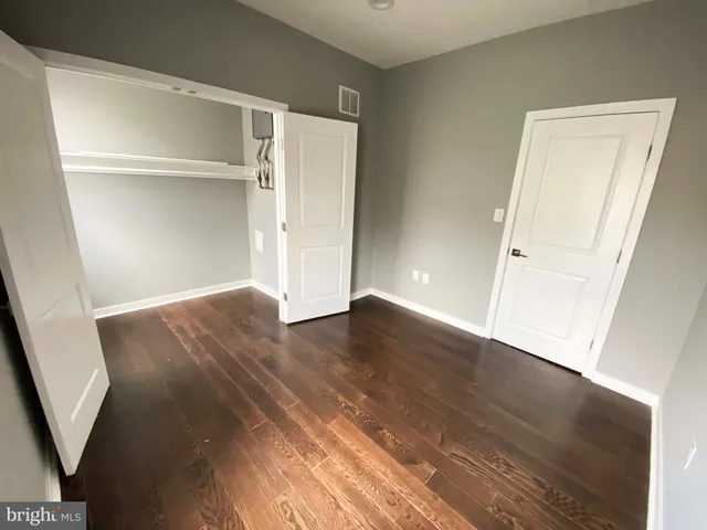an empty room with wooden floor and closet