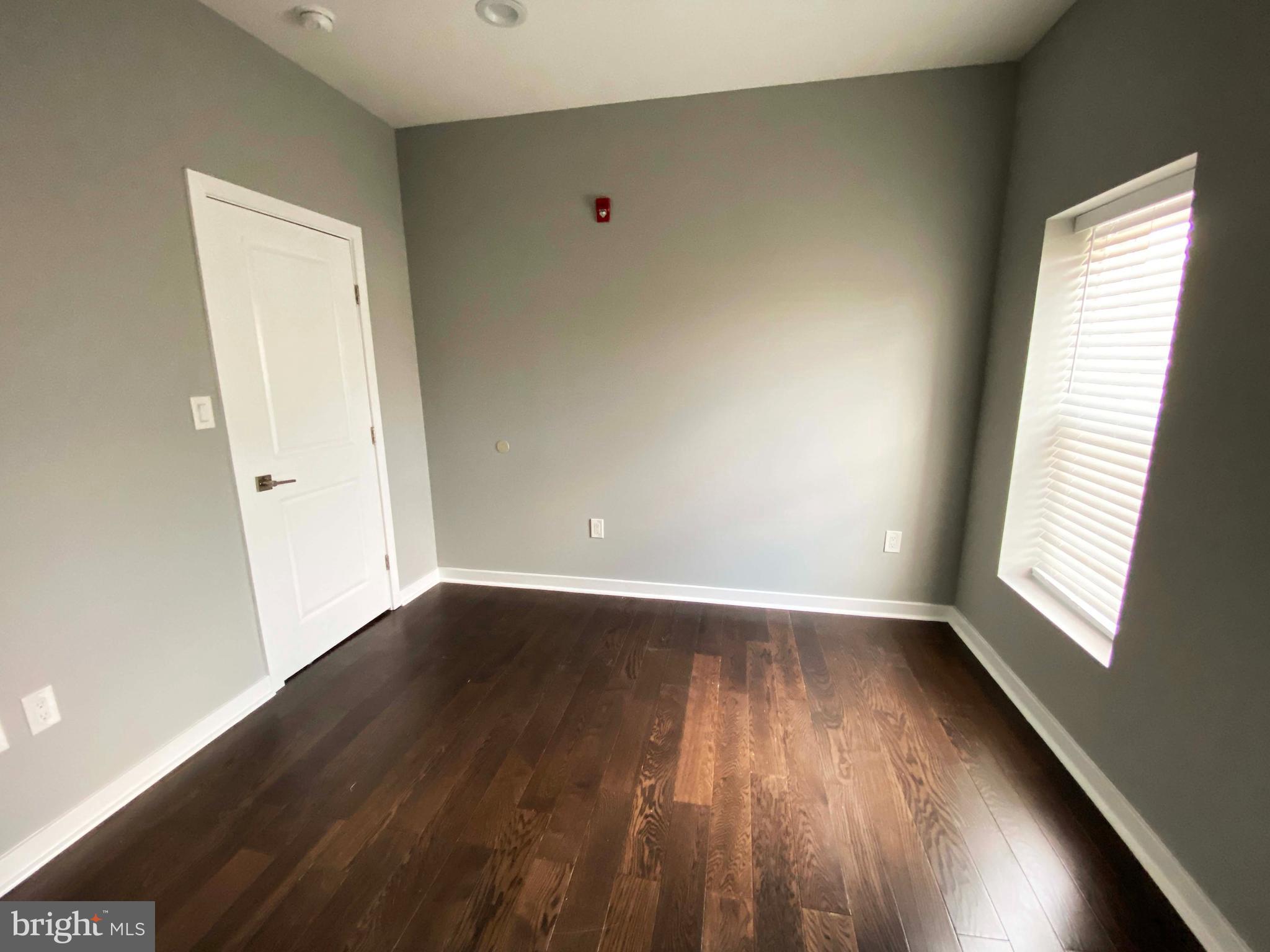 1801 West Venango Street, Unit 4 Philadelphia, PA 19140 - Photo 19 of 21 an empty room with wooden floor and windows