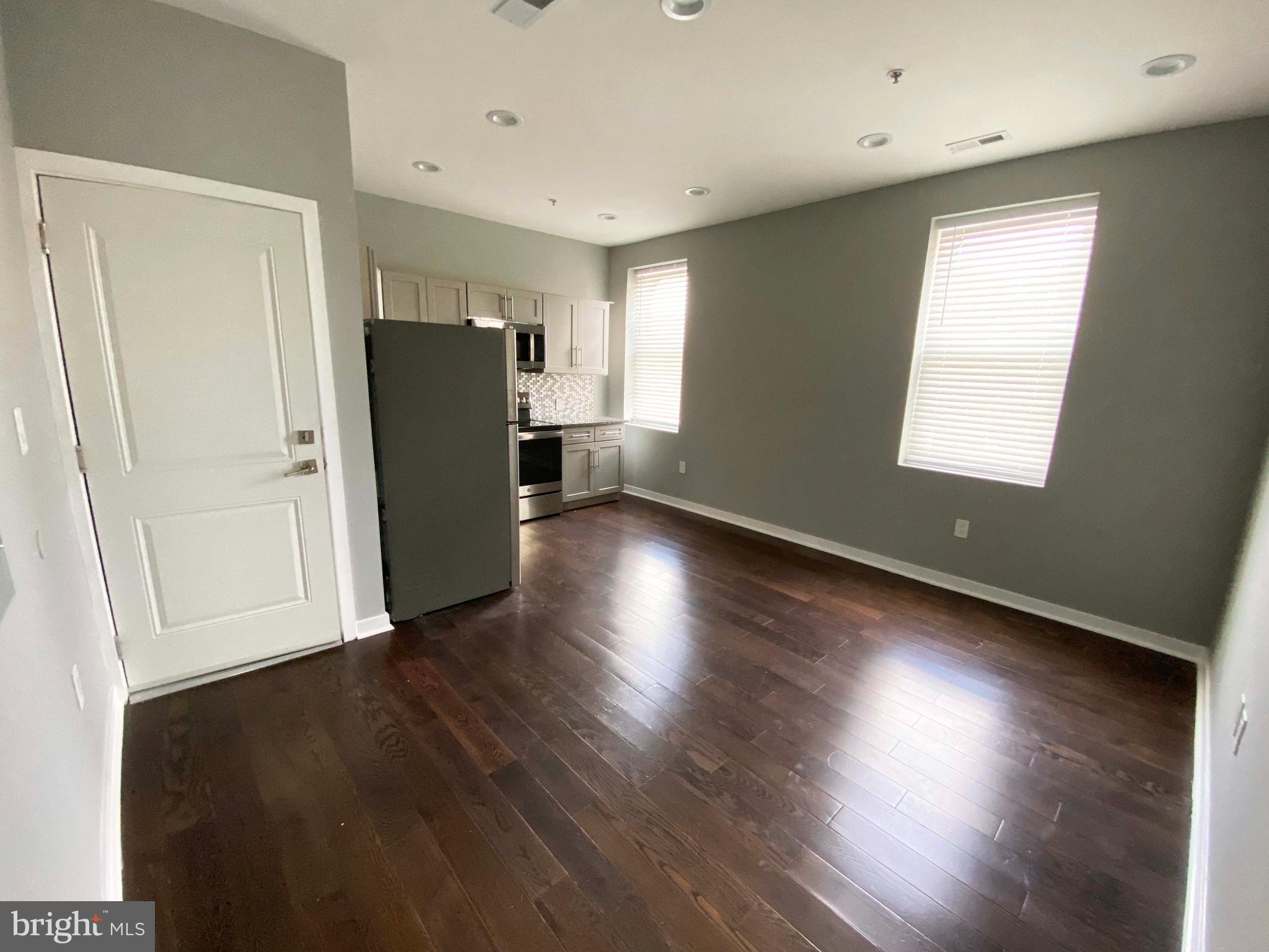 1801 West Venango Street, Unit 4 Philadelphia, PA 19140 - Photo 21 of 21 an empty room with wooden floor and windows