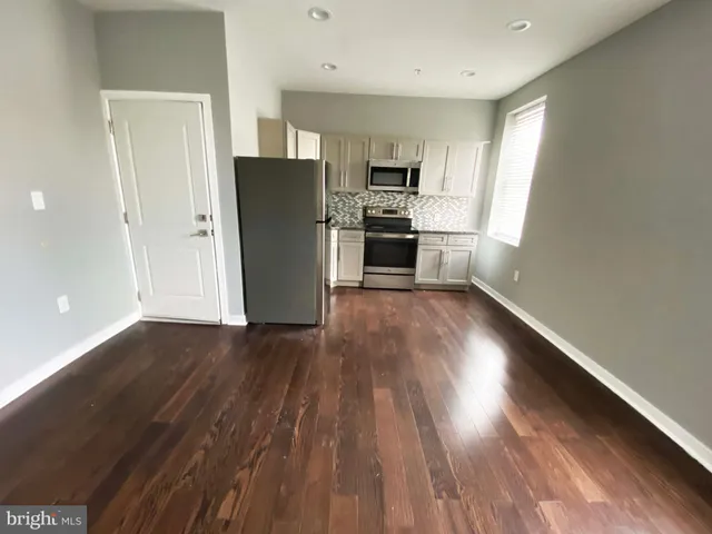 a view of kitchen with wooden floor electronic appliances and window