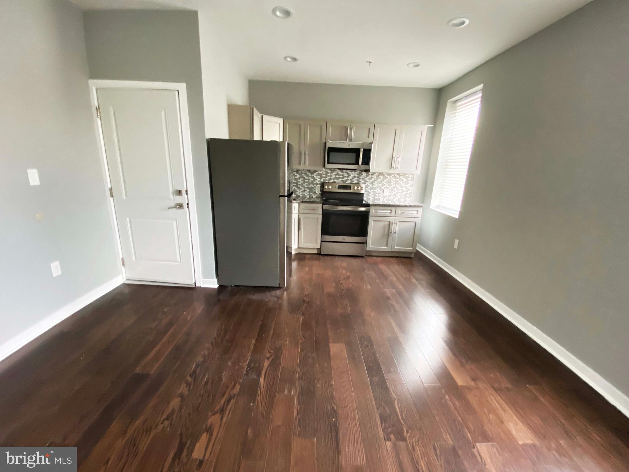 1801 West Venango Street, Unit 4 Philadelphia, PA 19140 - Photo 4 of 21 a view of kitchen with wooden floor electronic appliances and window