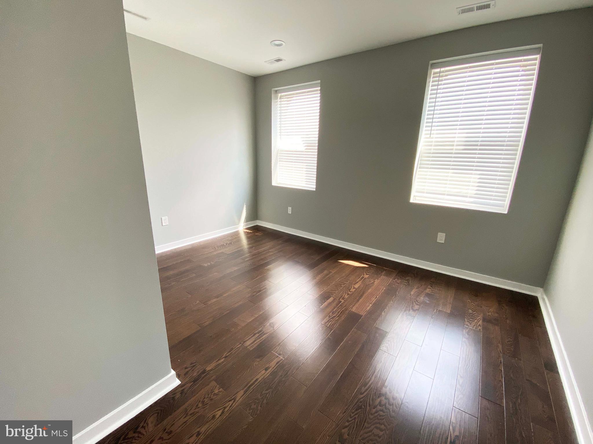 1801 West Venango Street, Unit 4 Philadelphia, PA 19140 - Photo 6 of 21 an empty room with wooden floor and windows