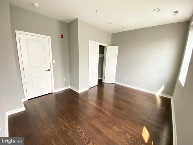 an empty room with wooden floor and closet