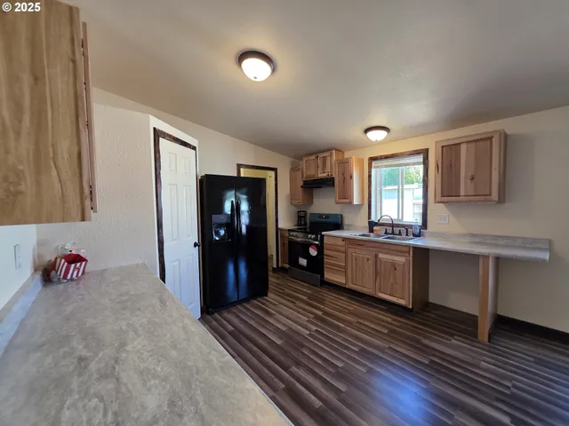 a kitchen with a refrigerator and a stove top oven