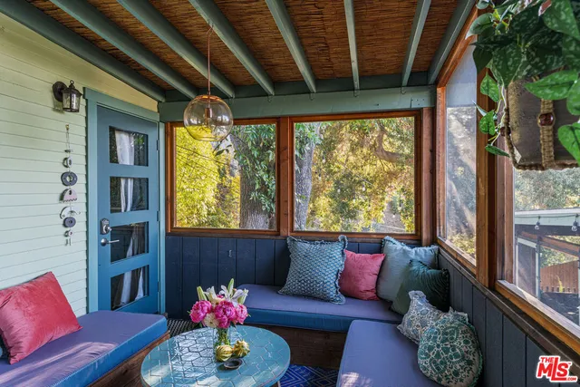 a view of a patio with couches chairs and wooden floor