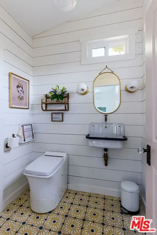 a view of a patio with table and chairs under an umbrella with wooden fence