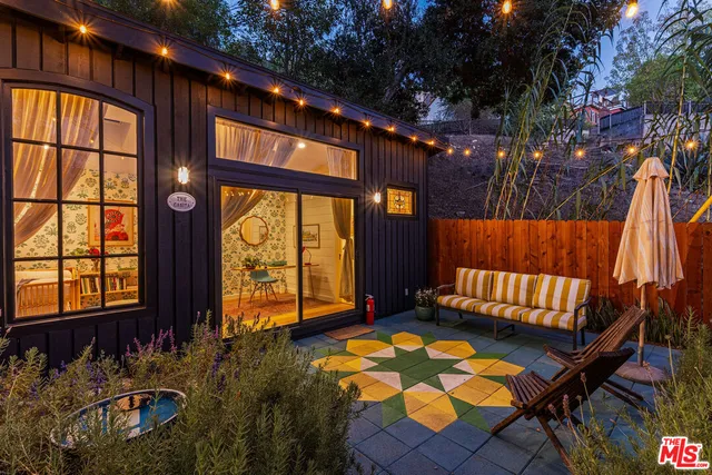 a view of porch with a couch and wooden floor next to a yard