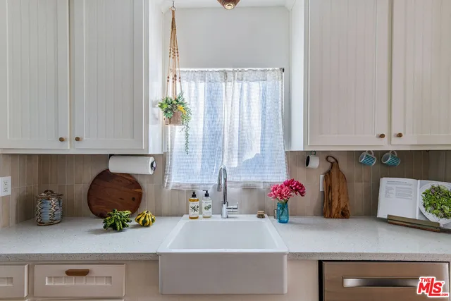 a kitchen with white cabinets and a potted plant