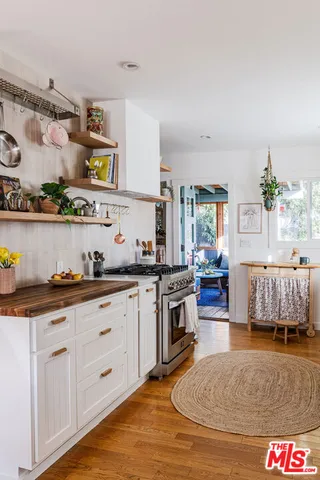 a kitchen with granite countertop a stove a sink and a refrigerator