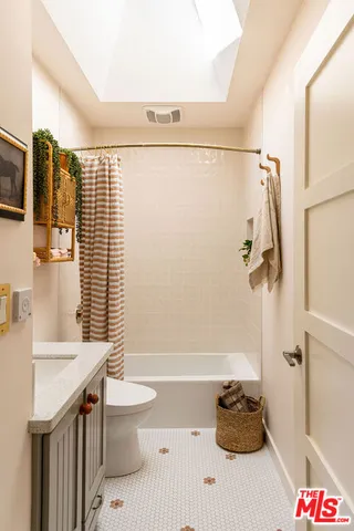 a bathroom with a granite countertop sink a toilet and shower