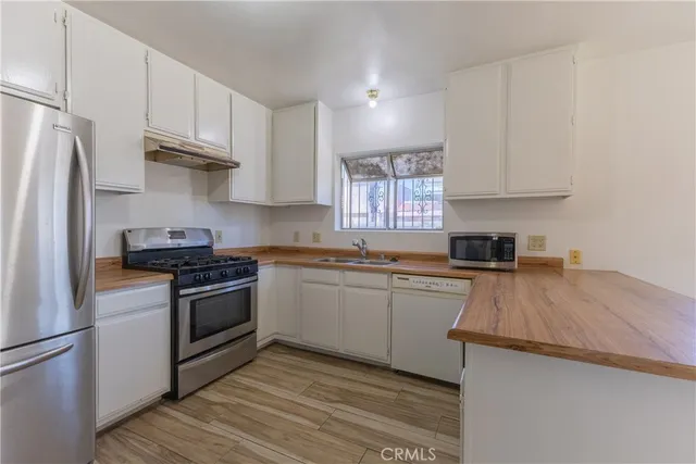 a kitchen with granite countertop a sink stove and refrigerator