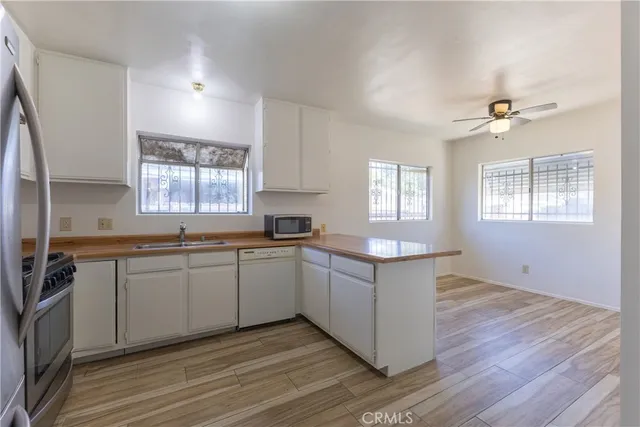 a kitchen with a sink cabinets wooden floor and a window