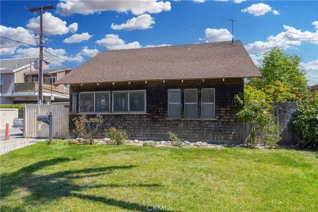 a front view of a house with a garden and yard