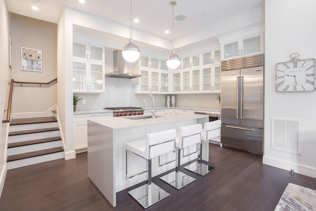 11 Exeter Street, Unit 3 Boston, MA 02116 - Photo 6 of 17 a kitchen with kitchen island a counter top space a sink stainless steel appliances and cabinets