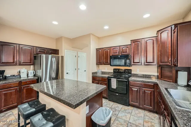 a kitchen with stainless steel appliances granite countertop a stove refrigerator sink and cabinets