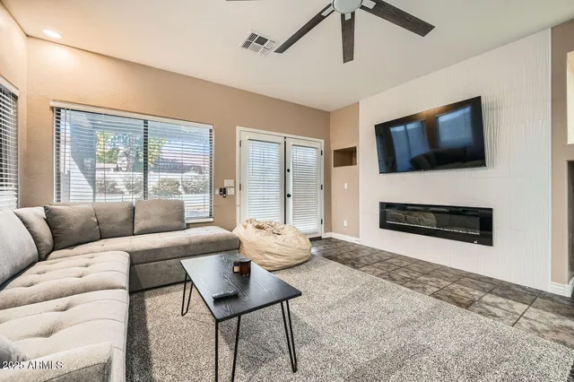 a living room with furniture a flat screen tv and a fireplace