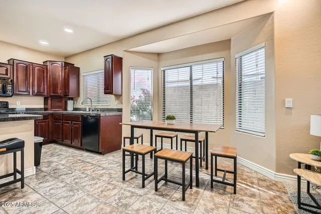 a kitchen with a table chairs sink and cabinets