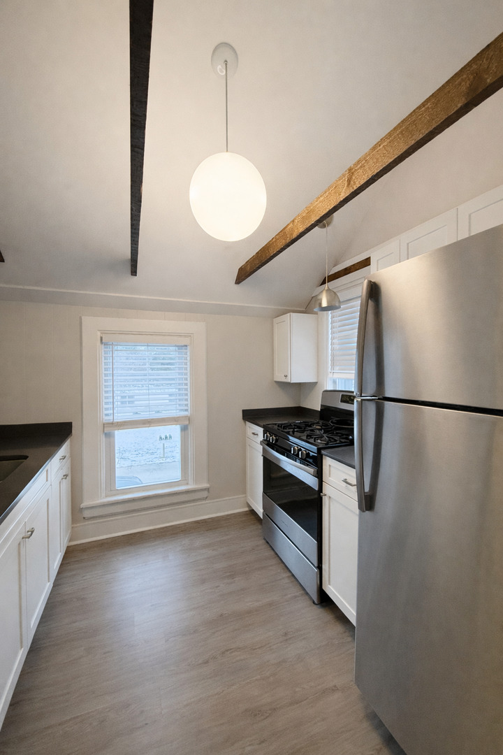 816 Fargo Boulevard, Unit 2 Geneva, IL 60134 - Photo 4 of 11 a kitchen with stainless steel appliances granite countertop a stove a sink and a refrigerator
