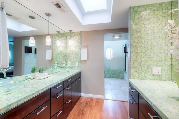 a bathroom with a granite countertop sink mirror bathtub and shower