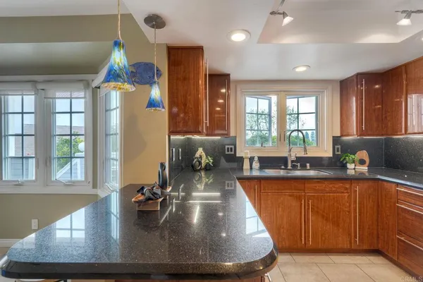 a large kitchen with kitchen island a large window in it