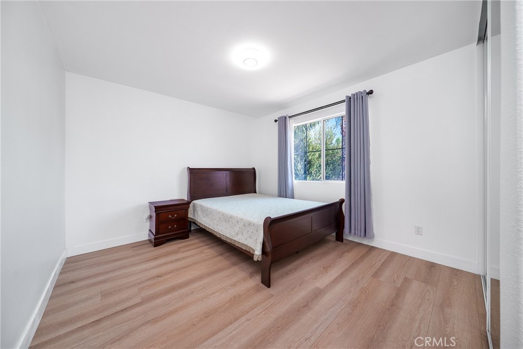 7358 Freedom Rancho Cucamonga, CA 91730 - Photo 23 of 34 a bedroom with a bed lamp and a window
