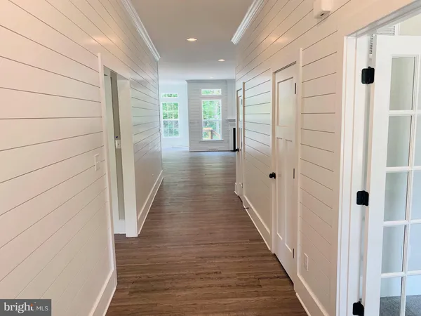 a view of a hallway with wooden floor and staircase