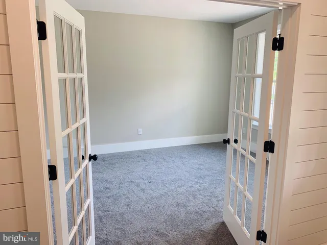an empty room with a white door and a window