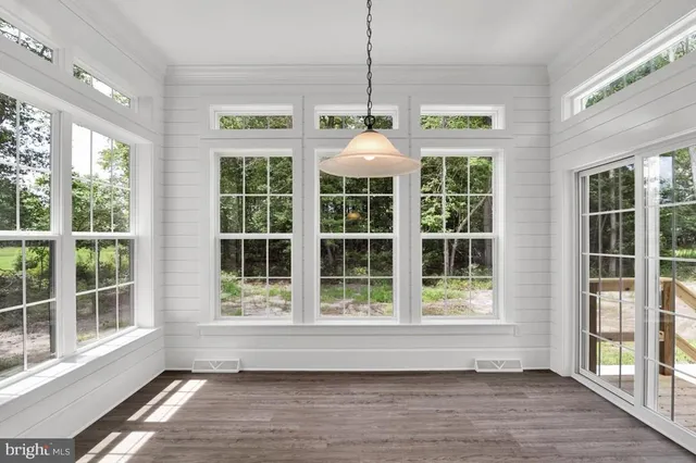 a floor to ceiling window and wooden floor