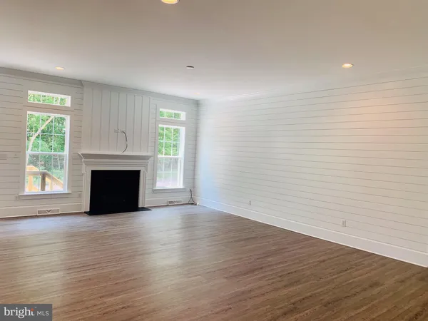 a view of empty room with wooden floor and fireplace