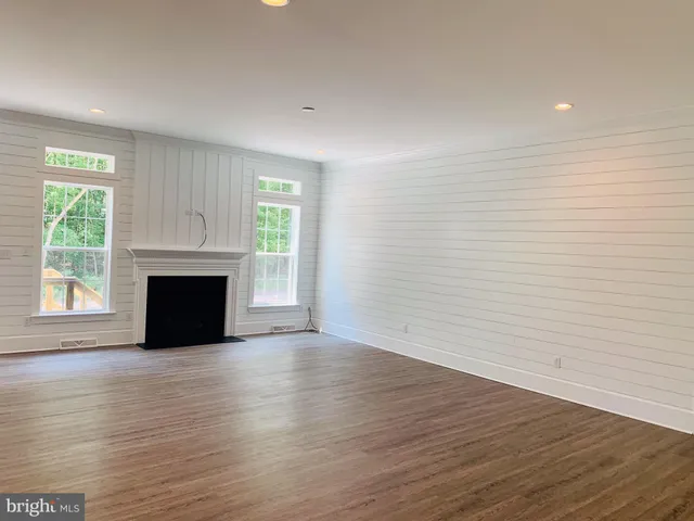 a view of empty room with wooden floor and fireplace