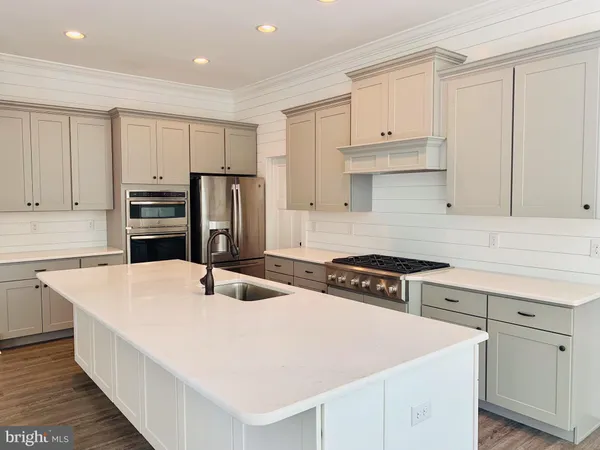 a kitchen with stainless steel appliances a stove refrigerator sink and cabinets