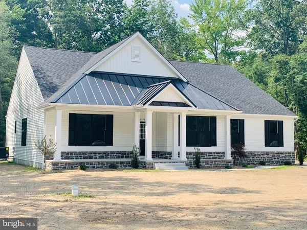 a front view of house with yard and trees in the background
