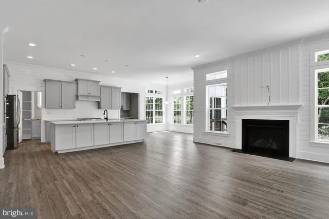 a large kitchen with cabinets wooden floor and a fireplace
