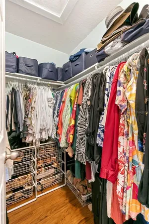 a view of walk in closet with clothes and shoes