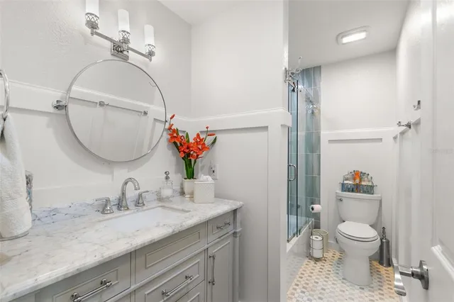 a bathroom with a granite countertop sink a toilet and a mirror